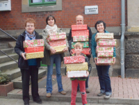 Dotzauer Dental übergibt die 48 selbstgepackten Weihnachtsgeschenke an die ehrenamtlichen Helfer der Sammelstelle der Aktion „Weihnachten im Schuhkarton“ im Pfarramt der Evangelischen Lutherkirche im Chemnitzer Stadtteil Schönau.